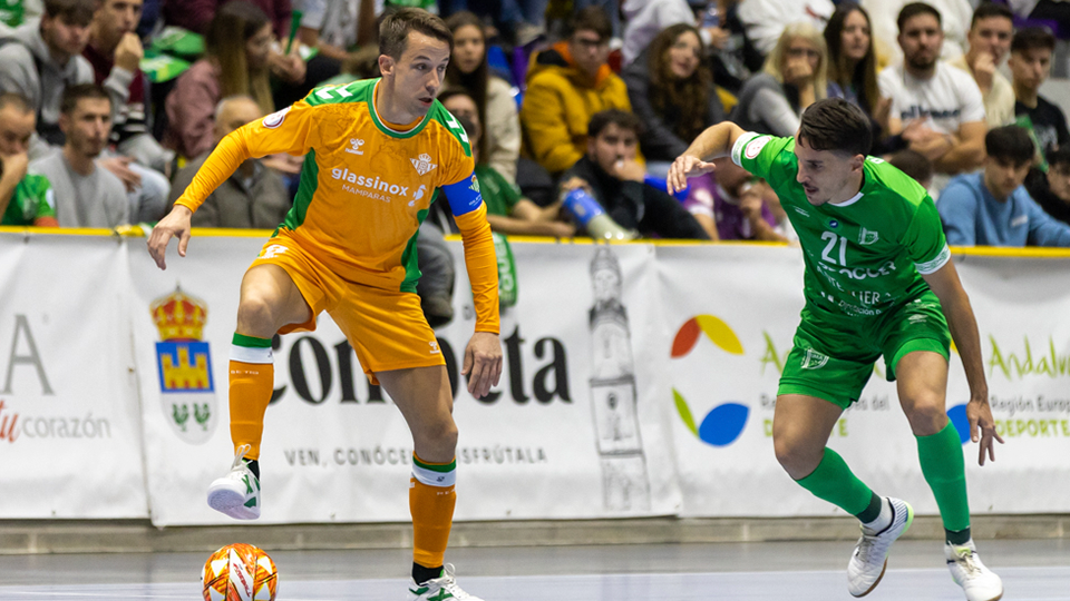 Lin, jugador del Real Betis Futsal, protege el balón ante Óscar, de BeSoccer CD UMA Antequera.