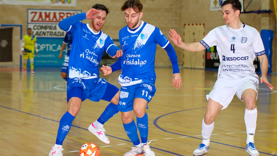 Rafa López y Álvaro López, de Quesos El Hidalgo Manzanares, ante la defensa de Pope, de BeSoccer CD UMA Antequera