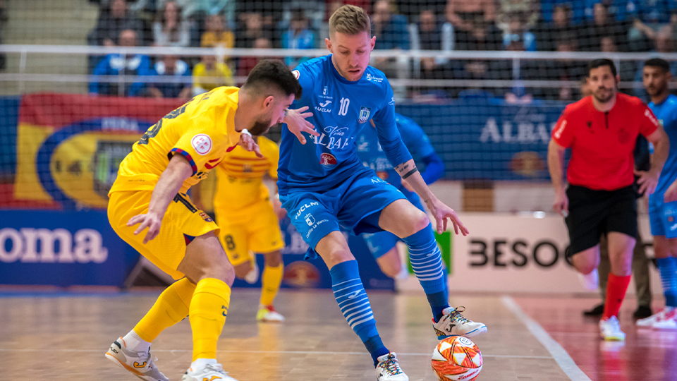 Batería, jugador de Viña Albali Valdepeñas, protege el balón ante Catela, del Barça