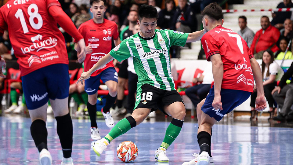 Henmi, del Real Betis Futsal, golpea el balón ante varios jugadores de Xota FS