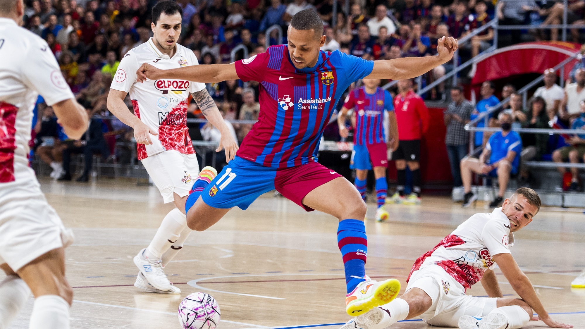 Ferrao, del Barça, arma la pierna ante la entrada de Alberto García, de ElPozo Murcia Costa Cálida