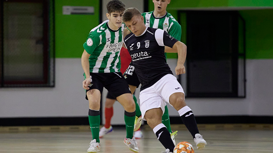 Cristian Rubio, jugador de Unión África Ceutí, controla la pelota ante la defensa de Real Betis Futsal